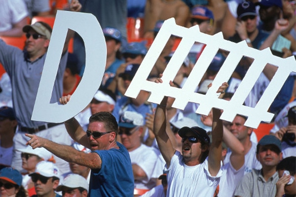 fans holding a defense sign at a football game