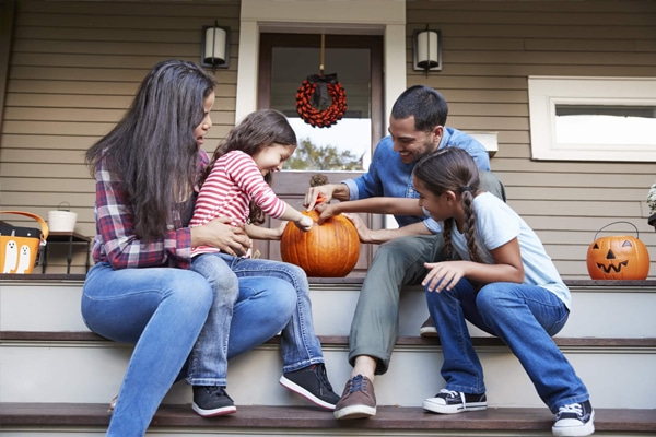 a family carving a pumpkin