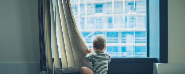 a child looking out a living room window