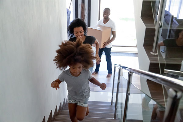 a family walking up the stairs of their new home