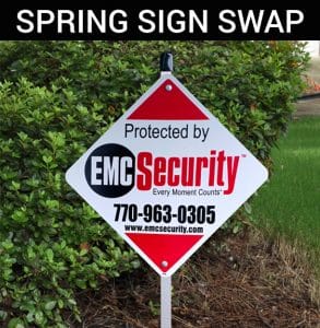SIGN SWAP an EMC security sign in front of a house